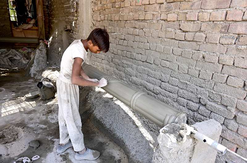Labourer Decorates Cement Pillar at Roadside Workplace