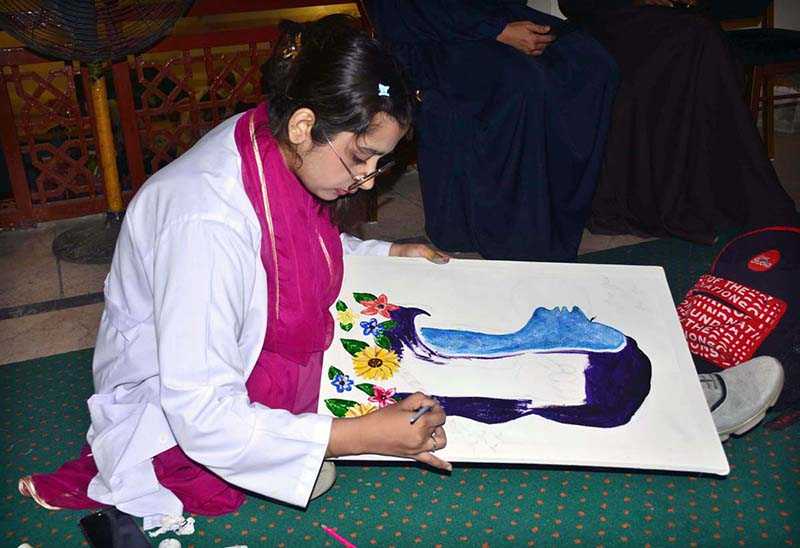 An art student busy in painting an art competition a painting competition, organized by the Punjab Arts Council Faisalabad